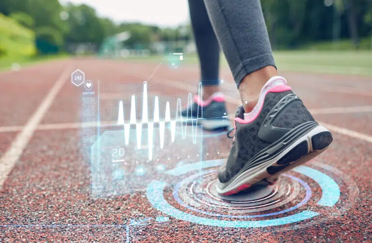 A woman's feet on a running track using wellness apps.
