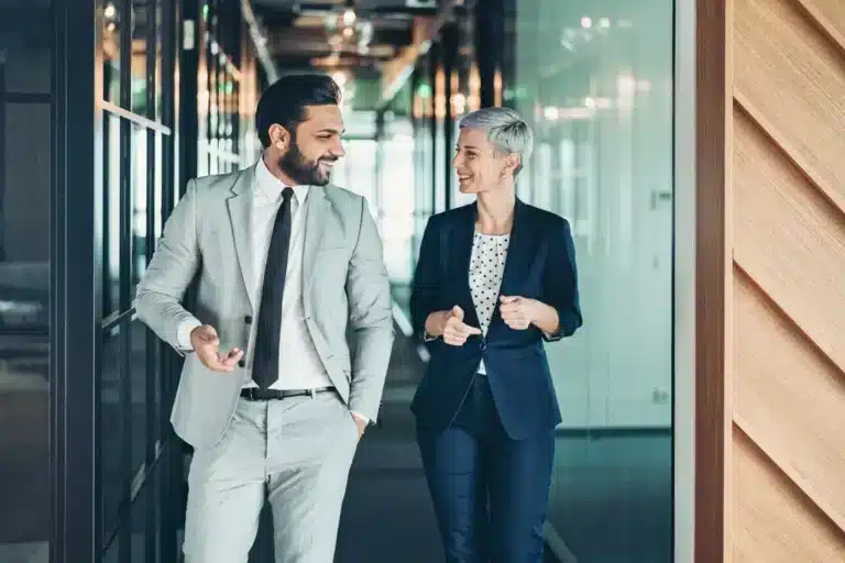 Two business people walking together in an office.