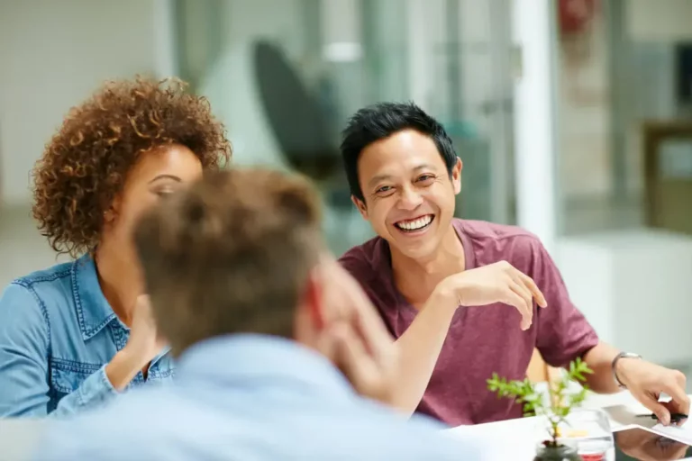 A group of people laughing at a meeting.
