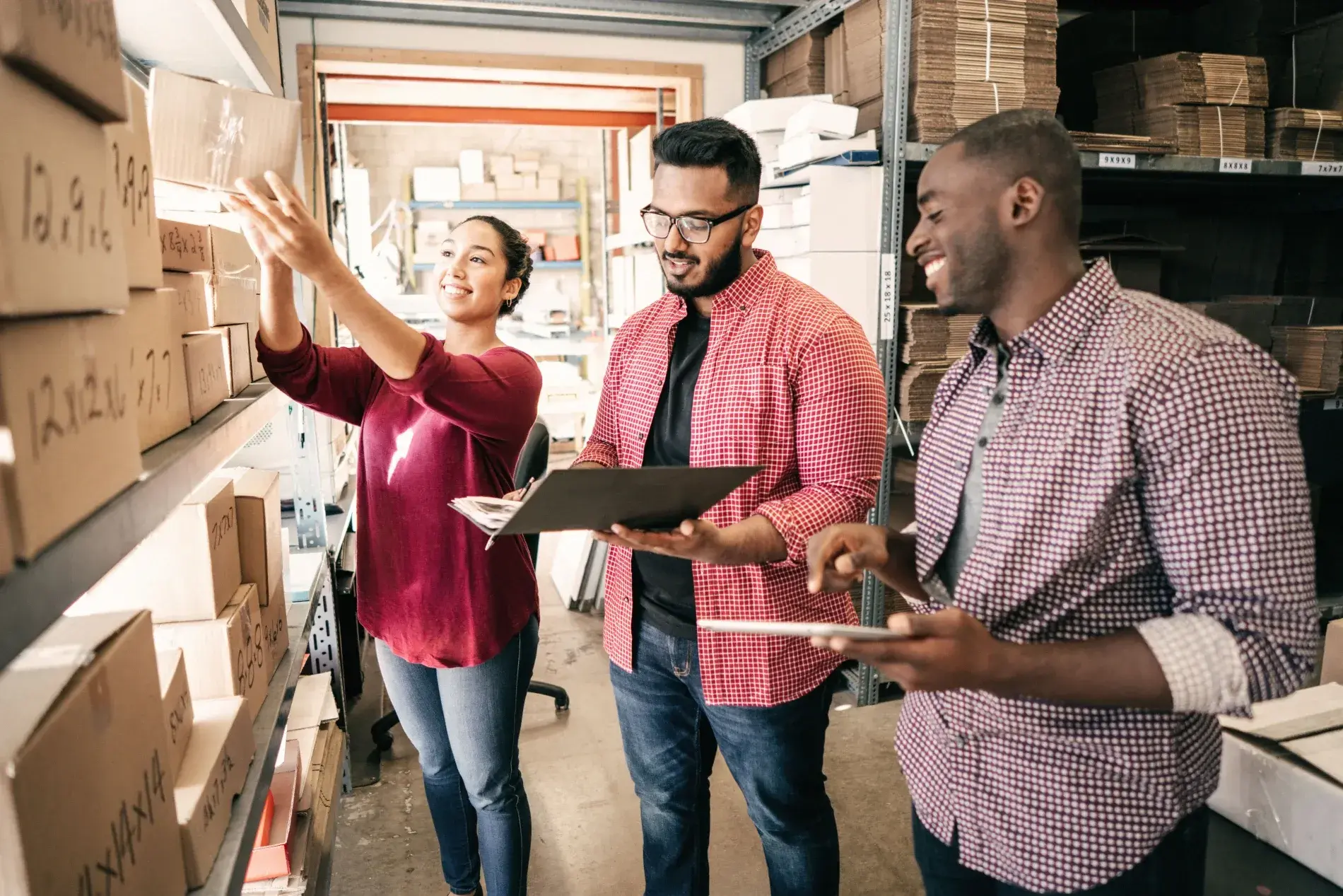 A group of people in a warehouse looking at boxes.