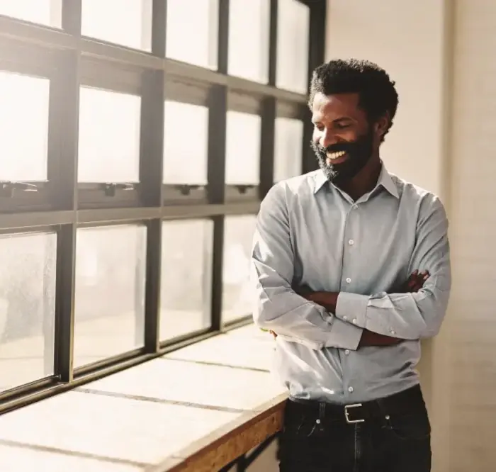 A black man standing in front of a window representing Technology Partners.
