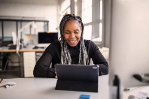A black woman using a tablet computer in an office.