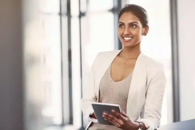 A business woman holding a tablet in an office.