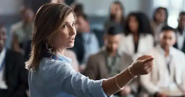 A woman giving a presentation to a group of people.