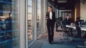A woman in a business suit walking through an office.
