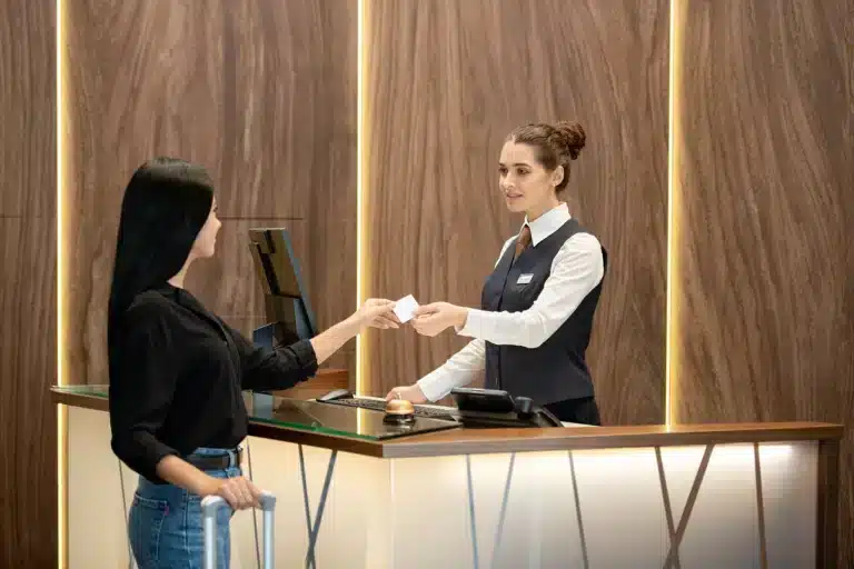 A woman managing accounting for travel agent commission at the front desk of a hotel