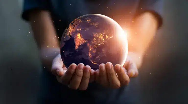 A woman is holding a globe in her hands, calculating her impact on the environment.