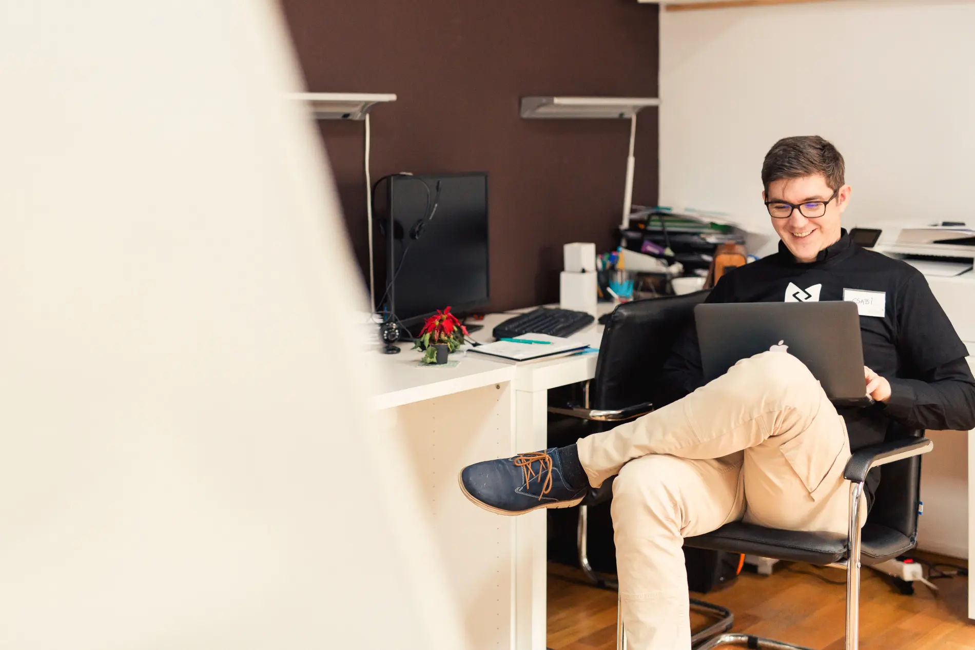 A man sitting in a chair and using a laptop.