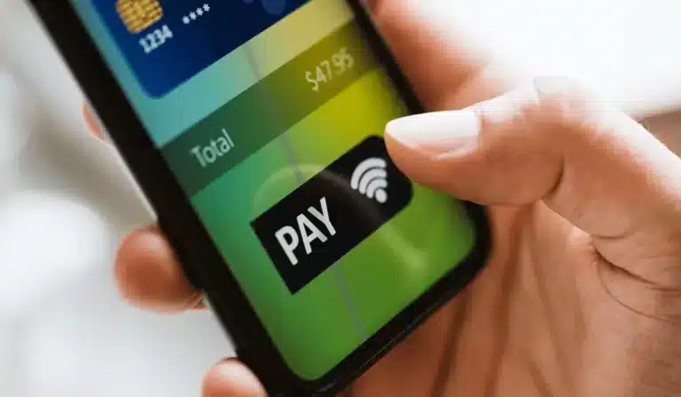 A person holding a smartphone with a global payouts button on it.