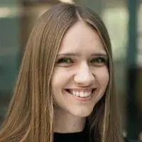 A young woman with long brown hair smiling.