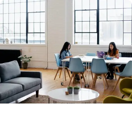 A group of people discussing career updates at a table in an office.