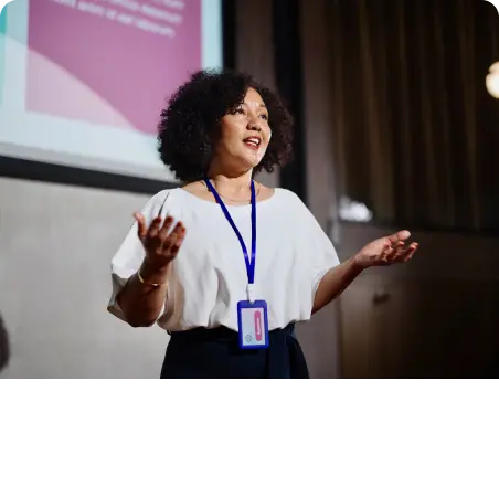 A woman delivering a career update presentation in front of a screen.