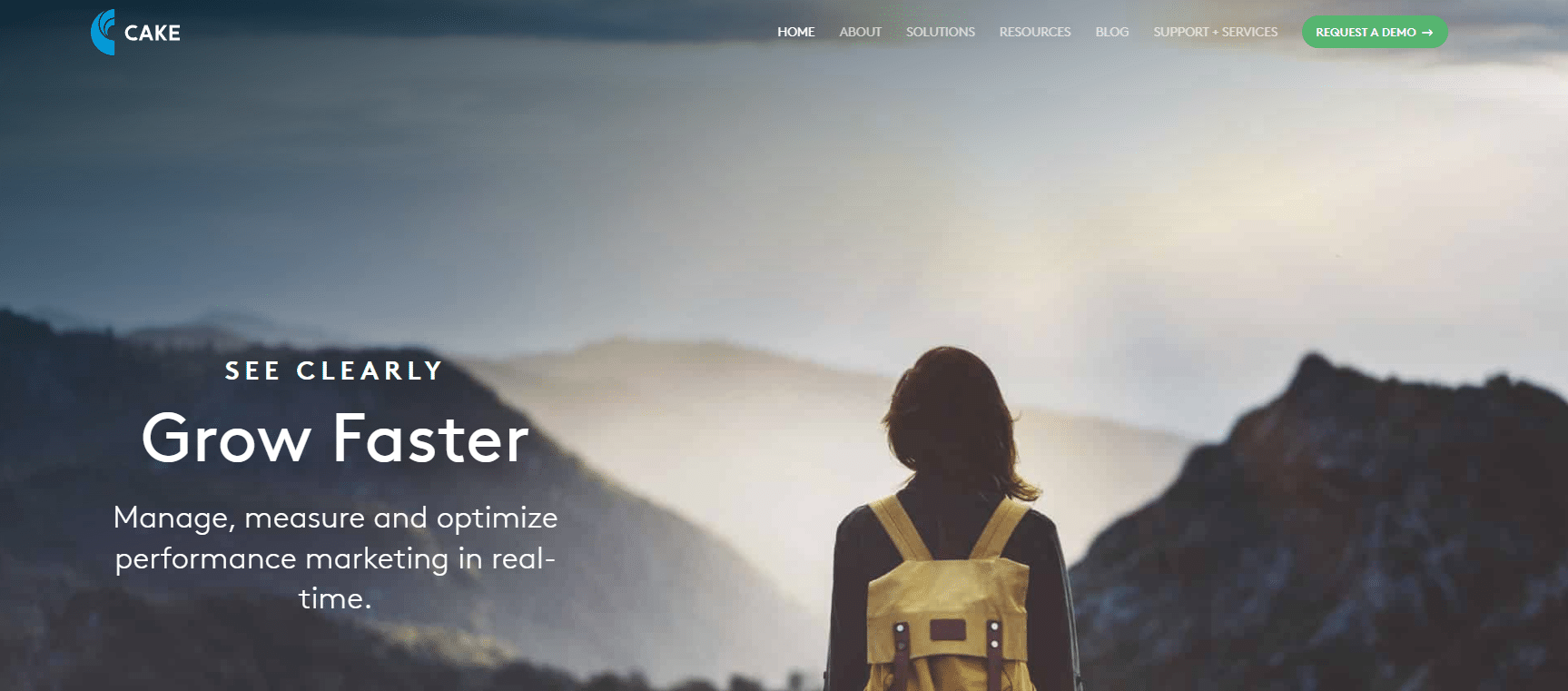 Person with yellow backpack stands on a mountain overlook at sunrise; website headline reads "Grow Faster" with navigation bar at the top, highlighting a powerful performance marketing platform.