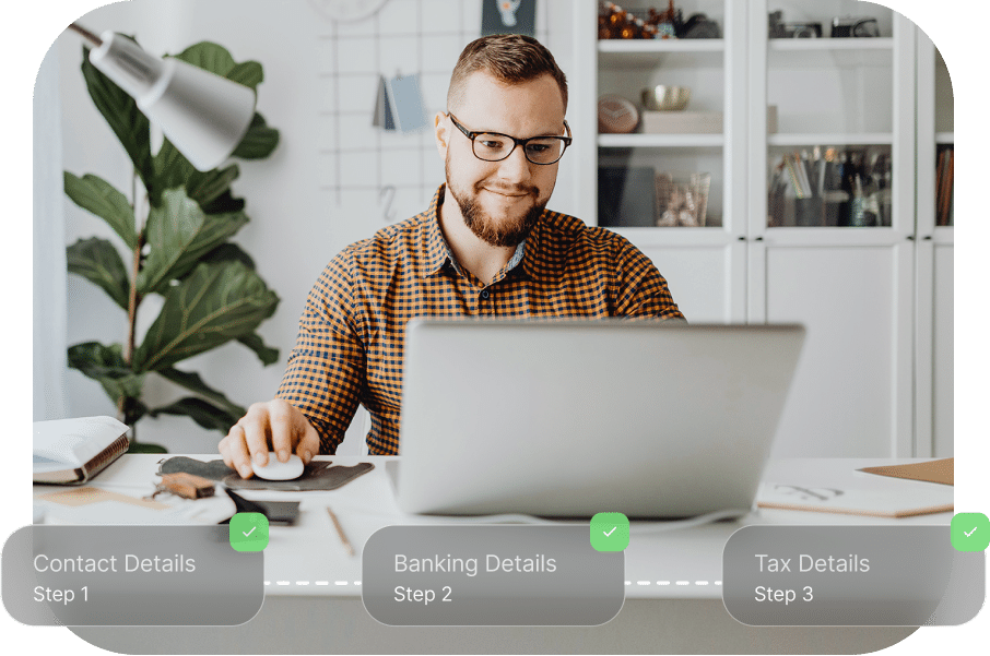 A man in glasses and a checkered shirt works on a laptop at a desk. Steps for Contact Details, Banking Details, and Tax Details are displayed at the bottom.