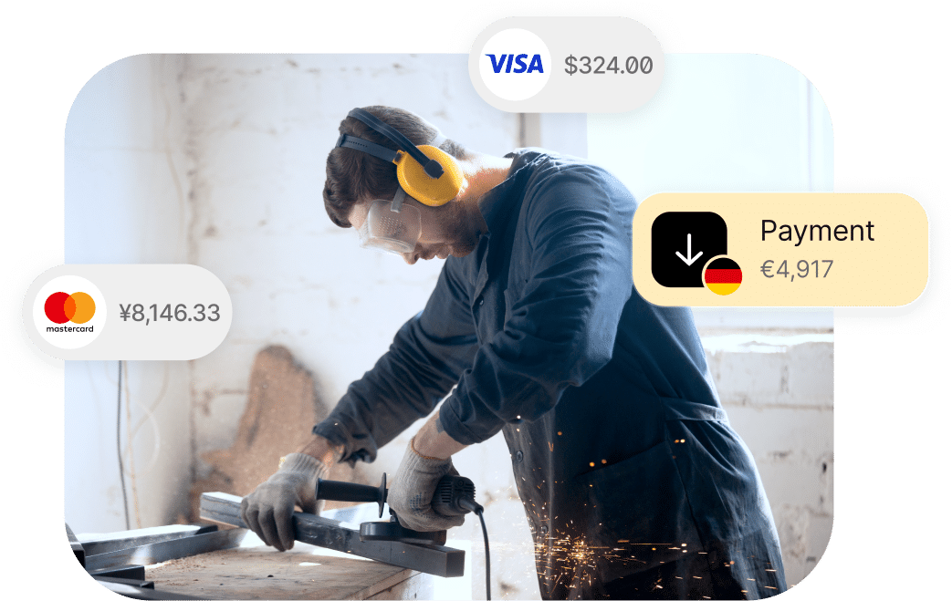 A person wearing ear protection and safety glasses uses a power tool on a piece of metal. Overlay icons show transaction amounts in various currencies.