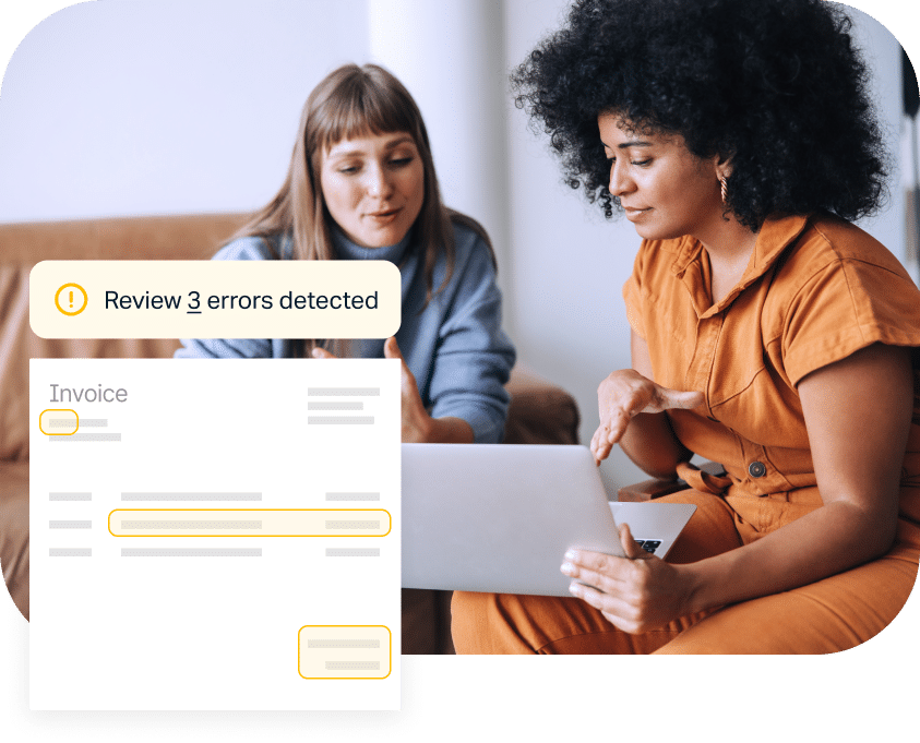 Two women are sitting and discussing something while looking at a laptop. A pop-up on the laptop screen indicates "Review 3 errors detected" in an invoice document.