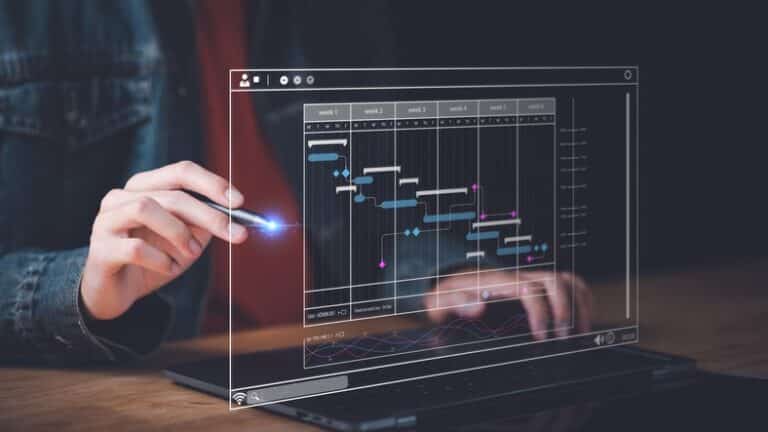 A person from various industries expertly interacts with a digital Gantt chart on a laptop screen, using a stylus.