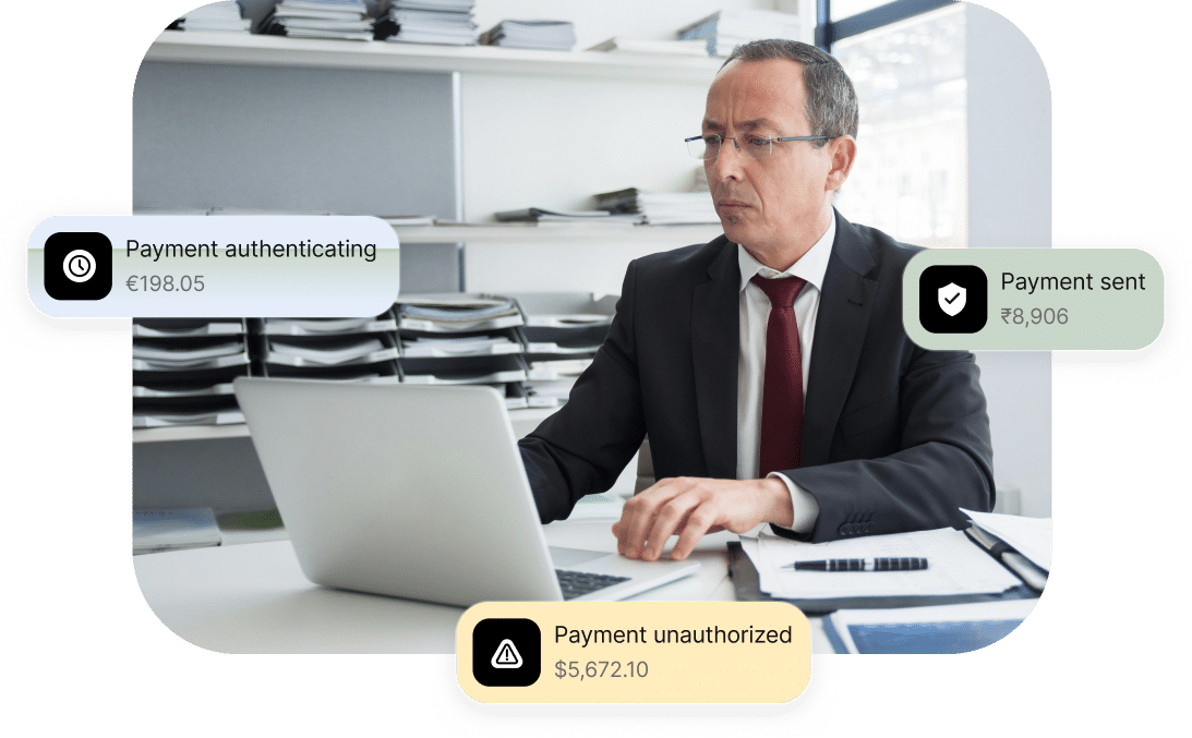 A man in an office works on a laptop. Three floating notifications show payment statuses: authenticating, sent, and unauthorized.