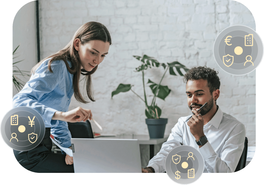 Two people are working together at a desk with a laptop. Digital icons depicting currency symbols and financial themes are overlaid on the image.