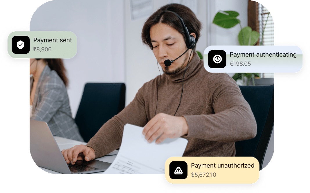 A person with a headset working at a desk with a laptop and papers. Three floating notifications show payment status: sent, authenticating, and unauthorized.