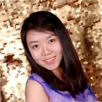 A young woman with long dark hair smiles at the camera, standing in front of a gold sequin backdrop.