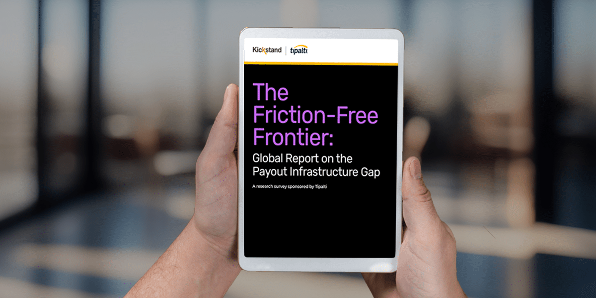Person holding a tablet displaying a digital report titled "The Friction-Free Frontier: Global Report on the Payout Infrastructure Gap" with logos for Kickstand and Toptal.