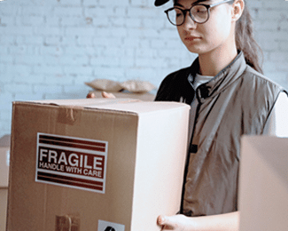 A delivery person holding a cardboard box with a “Fragile” label.
